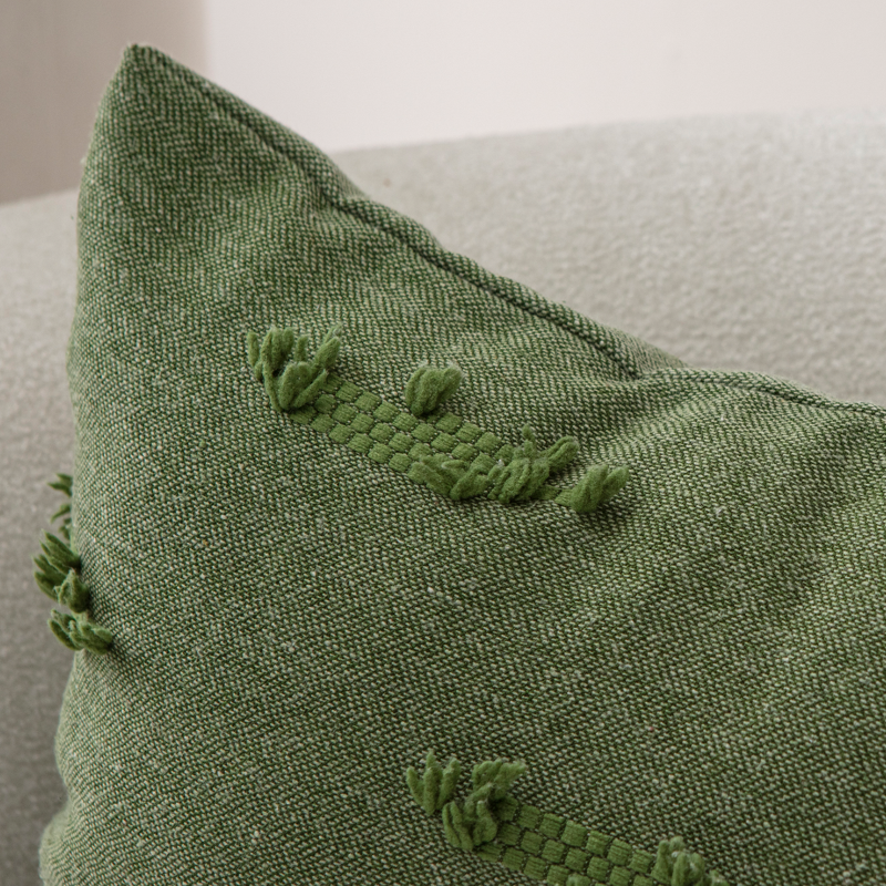 Olive green textured woven throw pillow on light sofa – decorative cushion with horizontal tufted details