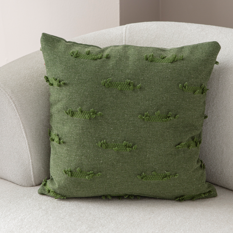 Olive green textured woven throw pillow on light sofa – decorative cushion with horizontal tufted details