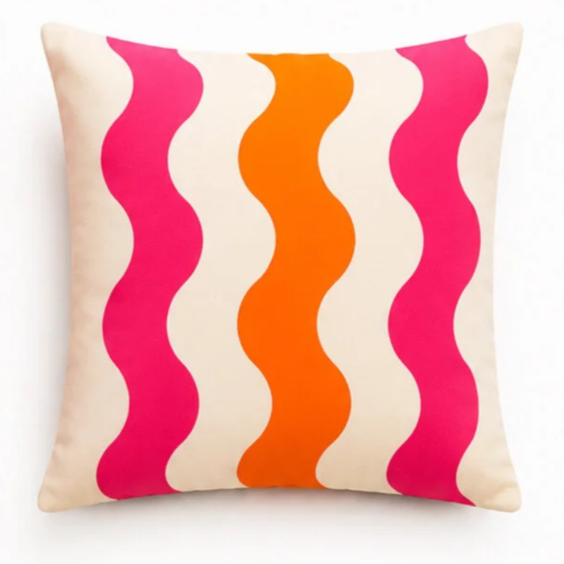 Set of four vibrant tropical decorative cushion covers featuring a cheetah illustration, abstract coral waves, bold white floral artwork, and a palm tree design displayed on a modern white sofa in a lush garden setting.