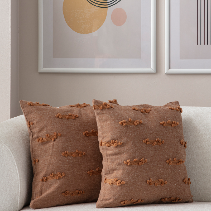 Warm brown woven textured throw pillow on light sofa – decorative cushion with horizontal tufted accents