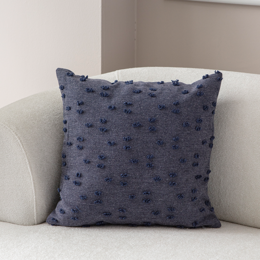 Navy blue tufted throw pillow on light sofa – textured decorative cushion