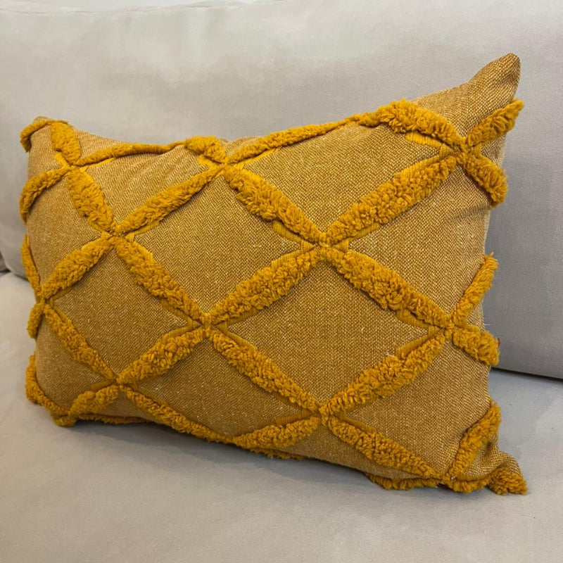 Mustard yellow textured decorative cushion cover with raised diamond pattern on beige sofa