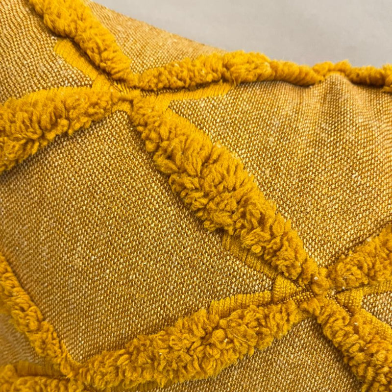 Burnt orange textured decorative cushion cover with raised diamond pattern on beige sofa