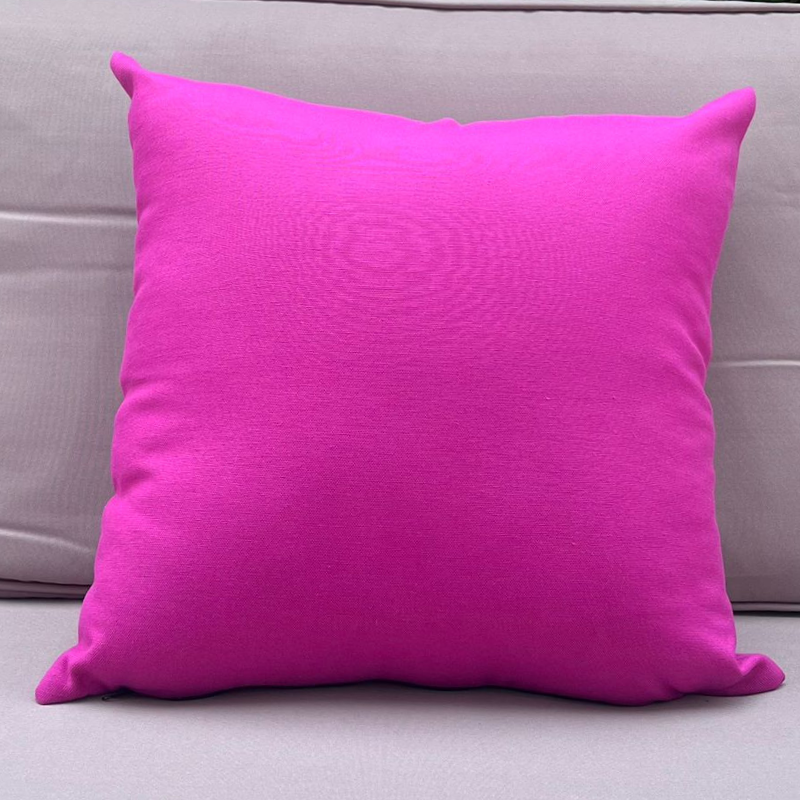 Fusia cushion cover displayed on a beige outdoor sofa in a garden patio setting