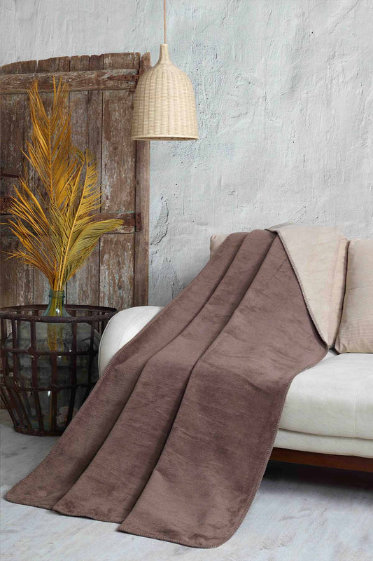 Double-face fleece blanket in pink and grey draped on chair