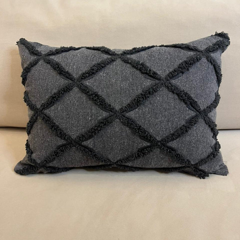 Charcoal gray textured decorative cushion cover with raised diamond pattern on beige sofa