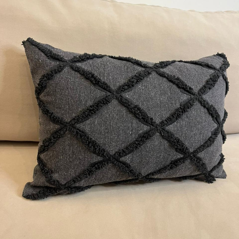 Charcoal gray textured decorative cushion cover with raised diamond pattern on beige sofa