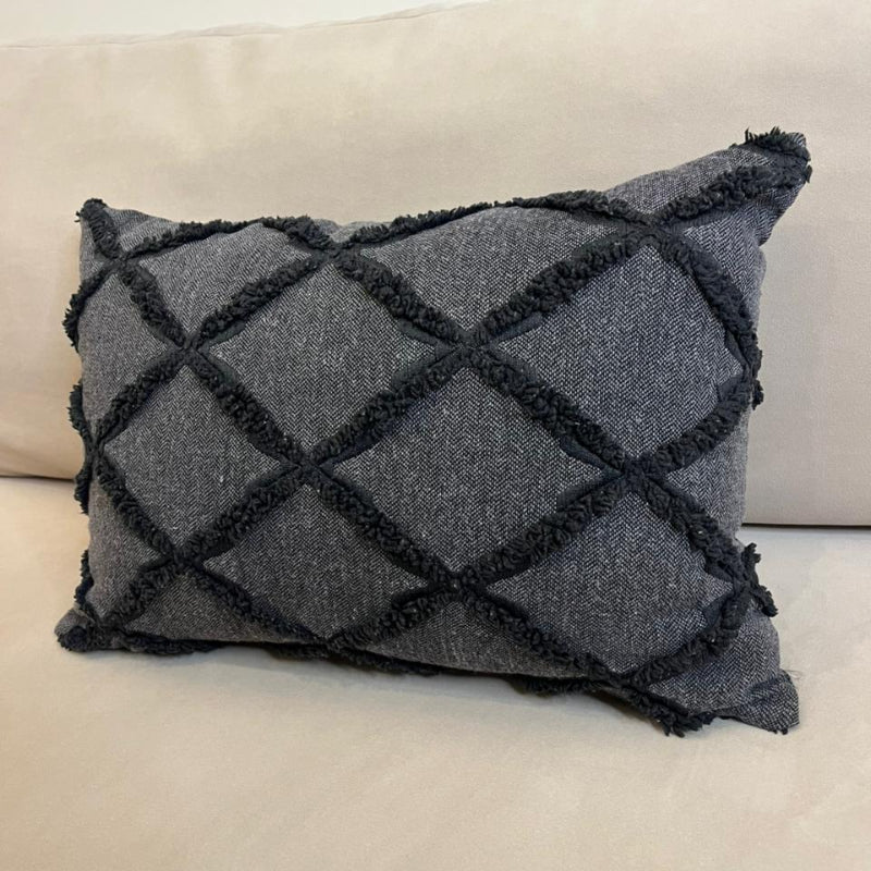 Charcoal gray textured decorative cushion cover with raised diamond pattern on beige sofa