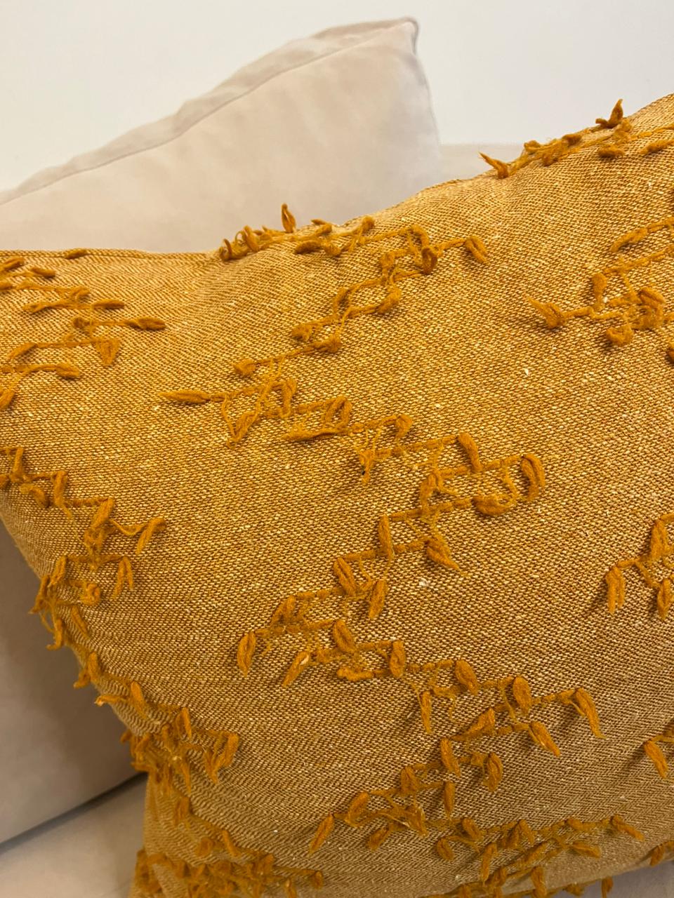 Burnt orange textured fringe decorative cushion cover with woven fabric on beige sofa