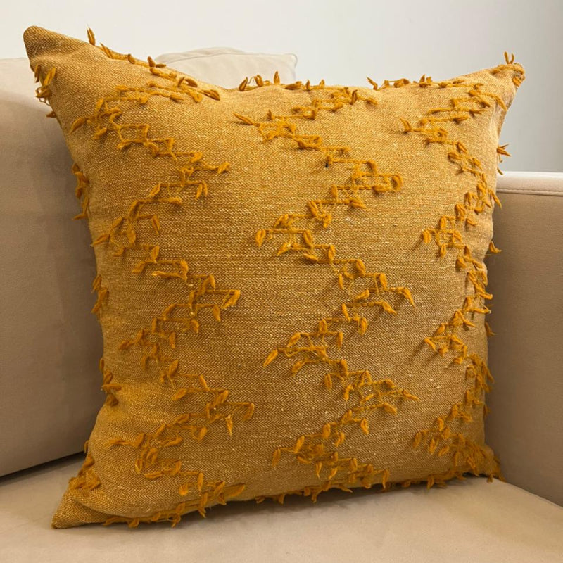 Burnt orange textured fringe decorative cushion cover with woven fabric on beige sofa