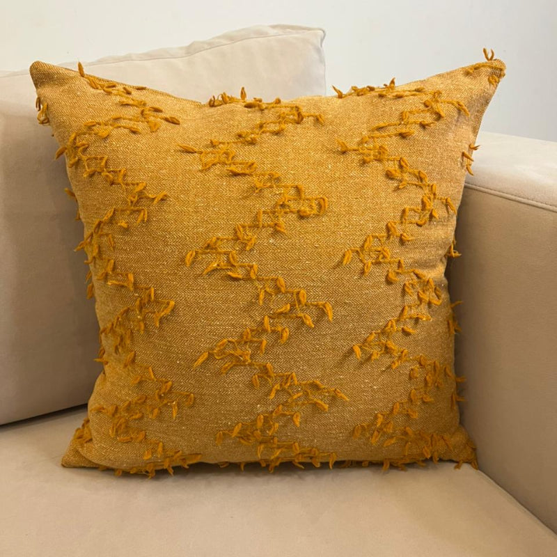 Burnt orange textured fringe decorative cushion cover with woven fabric on beige sofa