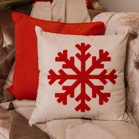 Beige cushion with embroidered red snowflake on a blue sofa – Autumn Bloom Collection