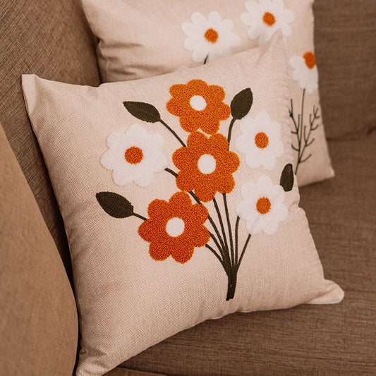 Beige cushion with embroidered bouquet of orange and white flowers on a blue sofa – Autumn Bloom Collection