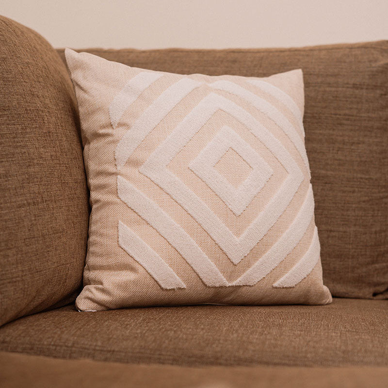 Beige cushion with diamond-pattern embroidery on a blue sofa – Autumn Bloom Collection