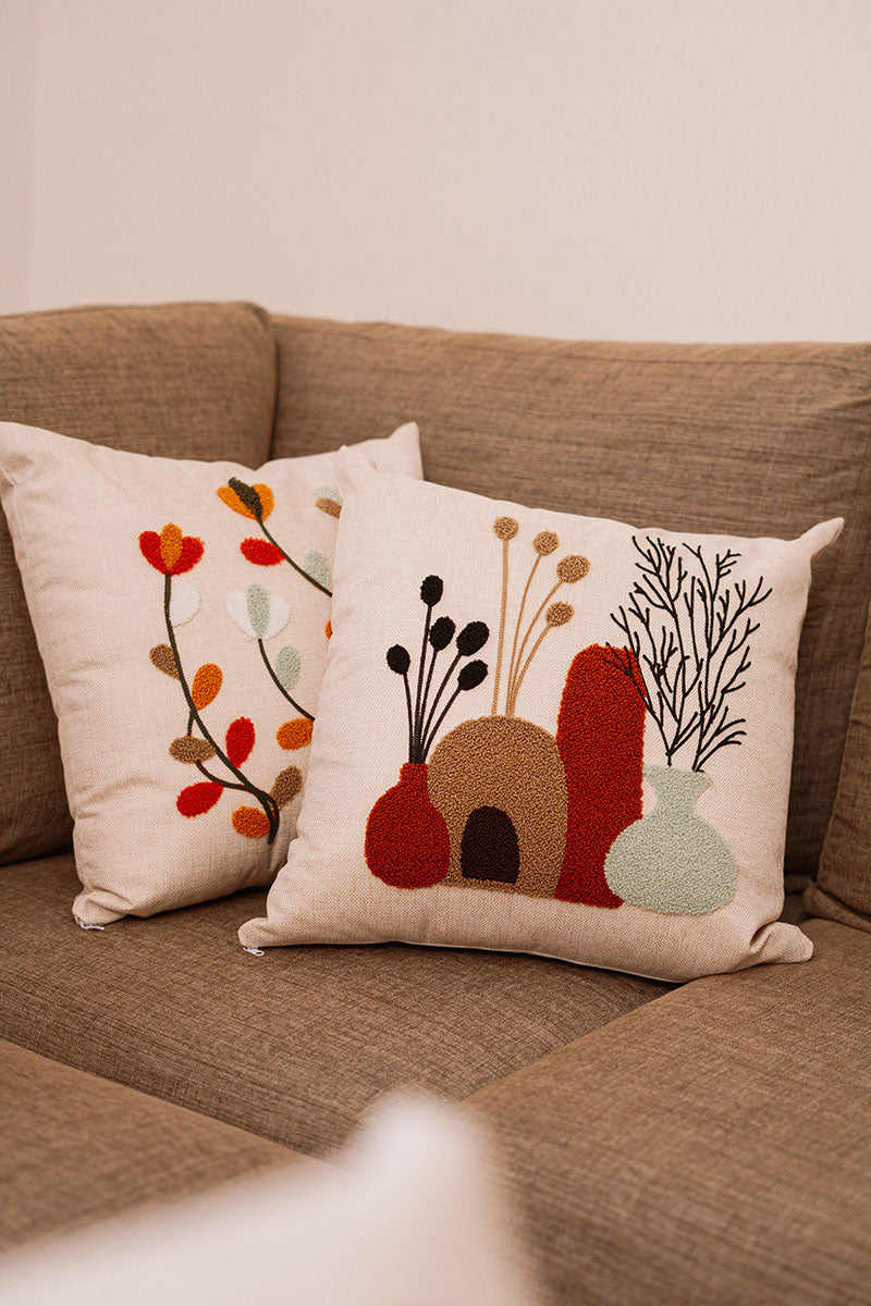 Beige cushion with embroidered multicolor autumn leaves on a blue sofa – Autumn Bloom Collection