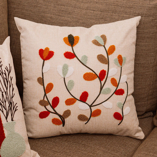 Beige cushion with embroidered multicolor autumn leaves on a blue sofa – Autumn Bloom Collection