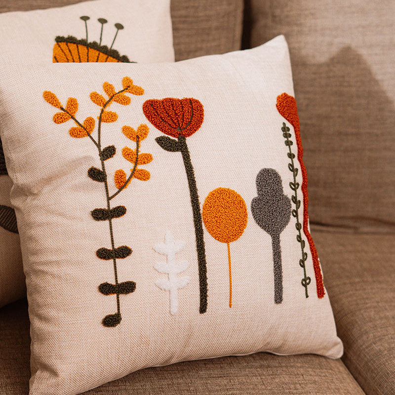 Beige cushion with multicolor embroidered flowers on a blue velvet sofa – Autumn Bloom Collection