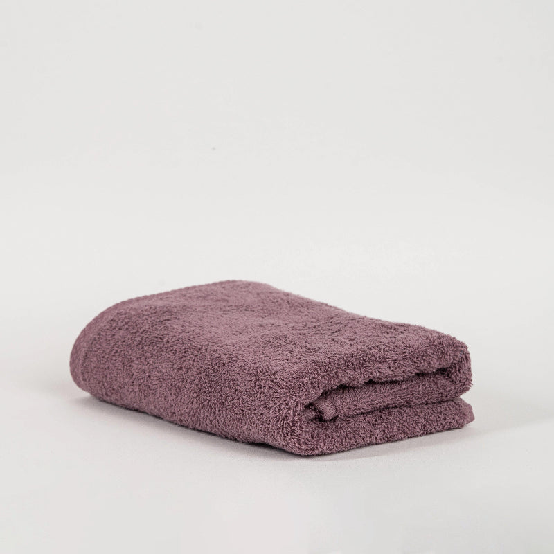 Absorbent plum purple cotton towel folded neatly.