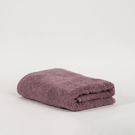 Absorbent plum purple cotton towel folded neatly.