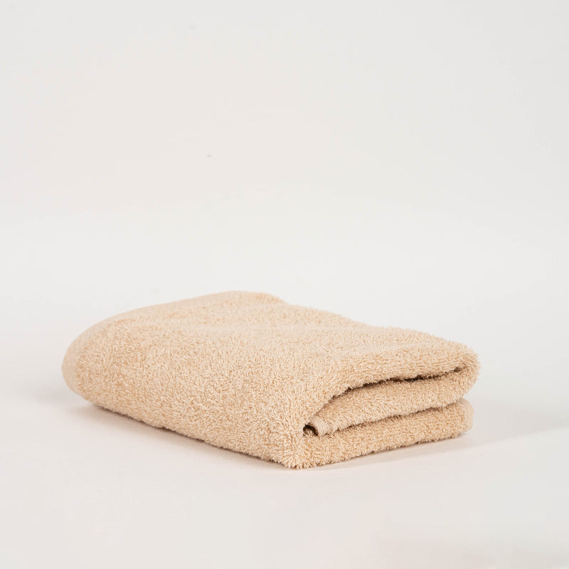 Absorbent terracotta brown cotton towel folded neatly.