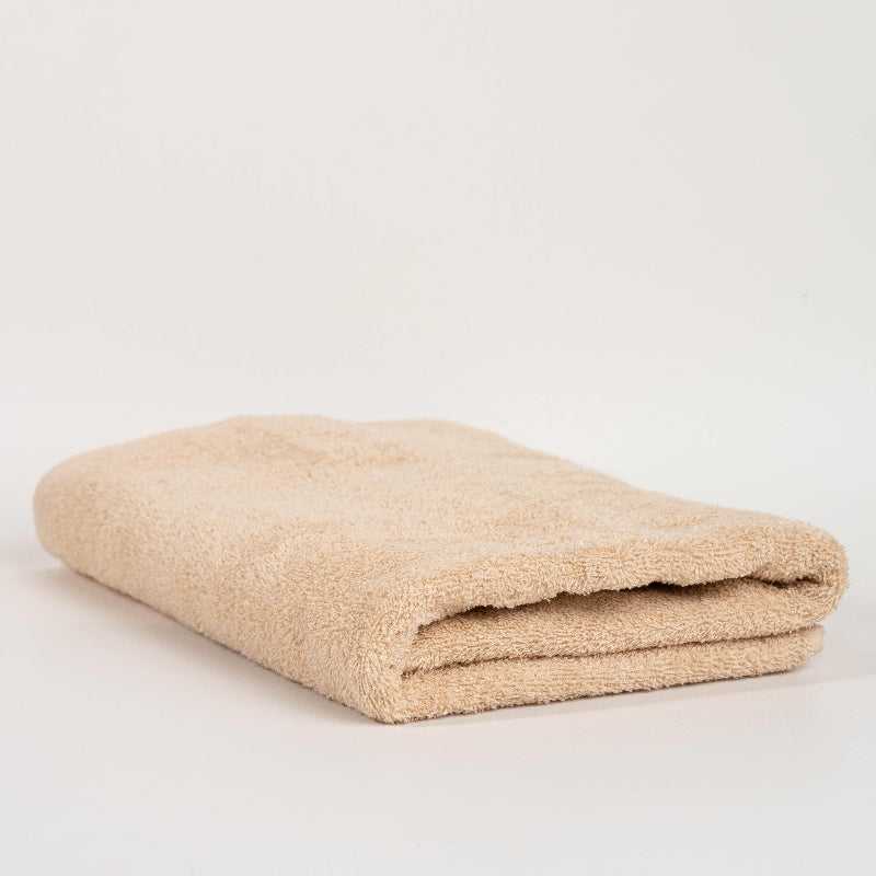 Absorbent terracotta brown cotton towel folded neatly.