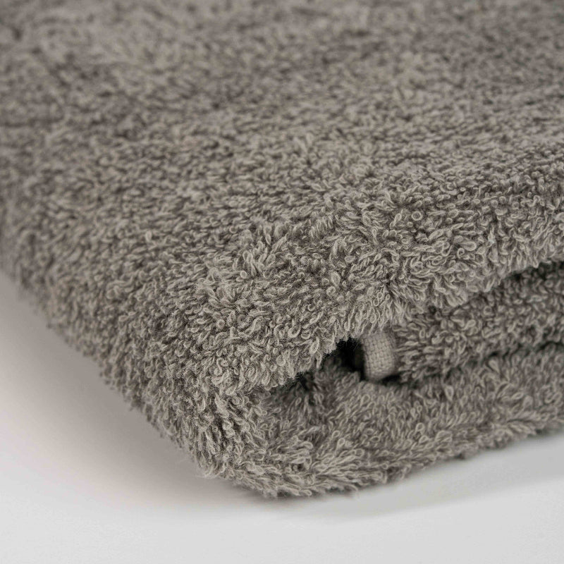 Absorbent stone grey cotton towel folded neatly.