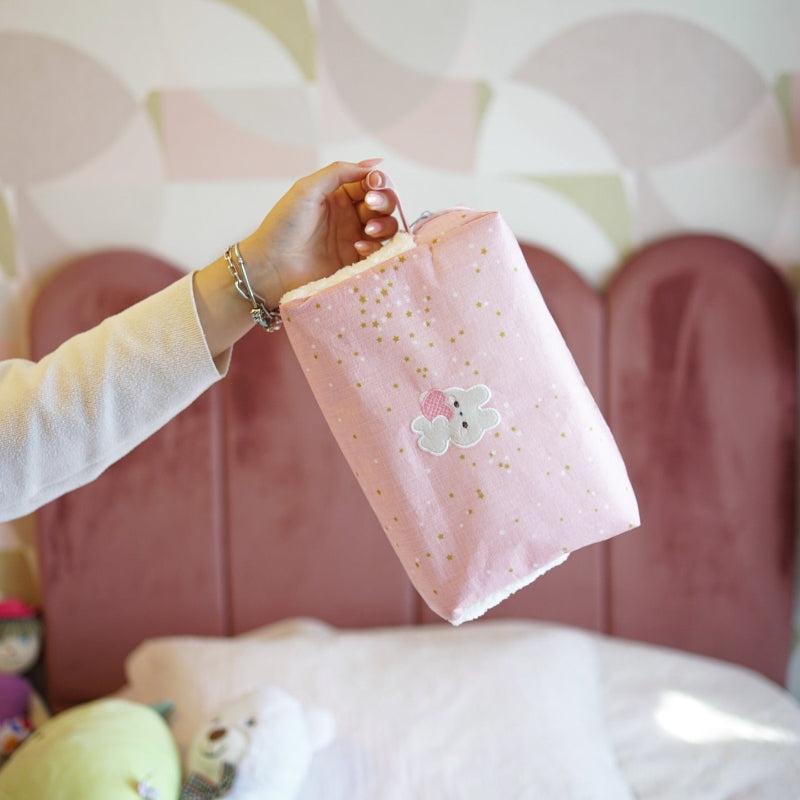 Pink baby nursery organizer set with decorative tissue box cover and zippered storage pouch placed on bed
