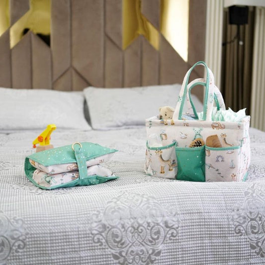 Portable baby diaper caddy organizer with compartments, filled with bottles, wipes, diapers, and teddy bear