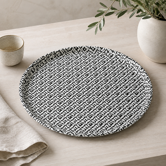Round ceramic plate with black geometric pattern on a white background