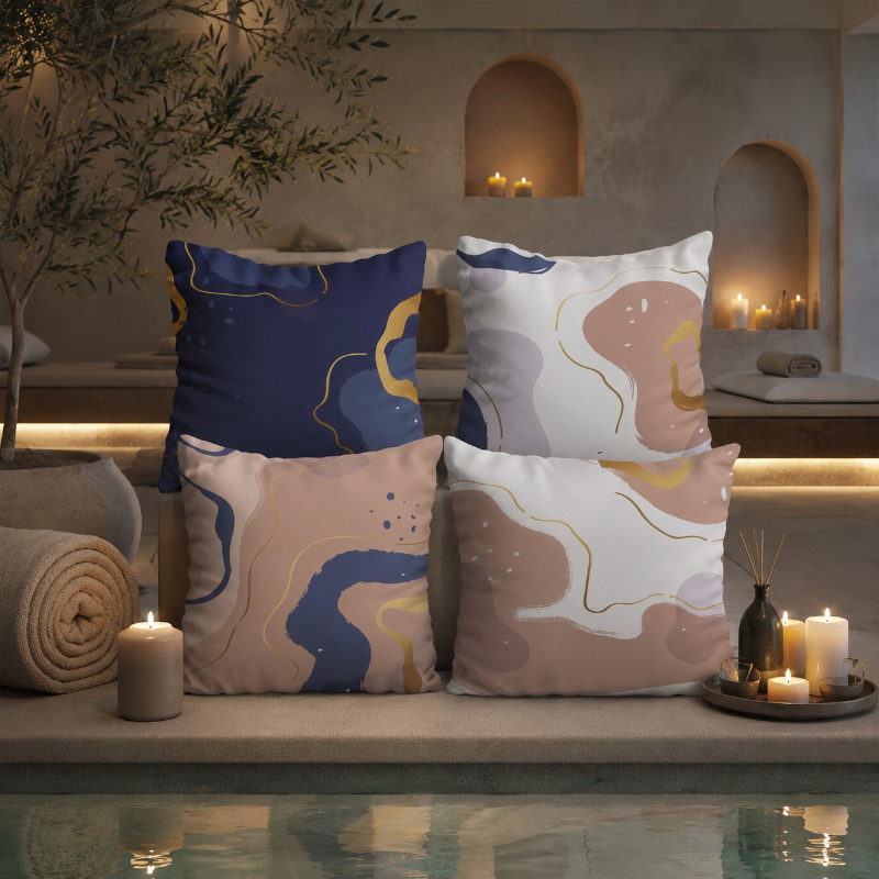 Warm neutral cushion cover with abstract shapes in beige, blue, and gold tones on a decorative pillow