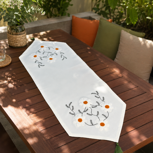 White hand embroidered floral table runner with orange flower details on wooden coffee table