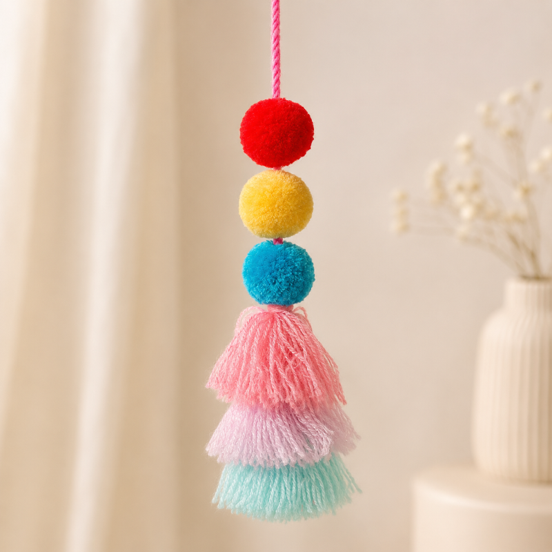 Handmade pom pom tassel hanging decor with colorful pom poms and layered pastel yarn tassels on white door background