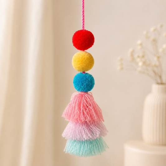 Handmade pom pom tassel hanging decor with colorful pom poms and layered pastel yarn tassels on white door background