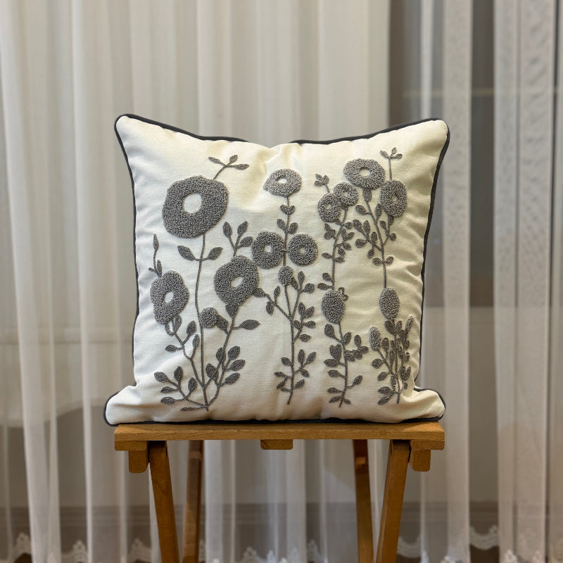 Cream square cushion cover with grey tufted floral embroidery and dark trim