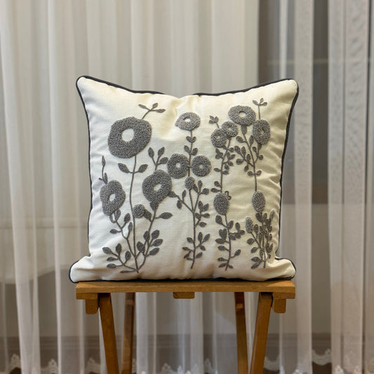 Cream square cushion cover with grey tufted floral embroidery and dark trim