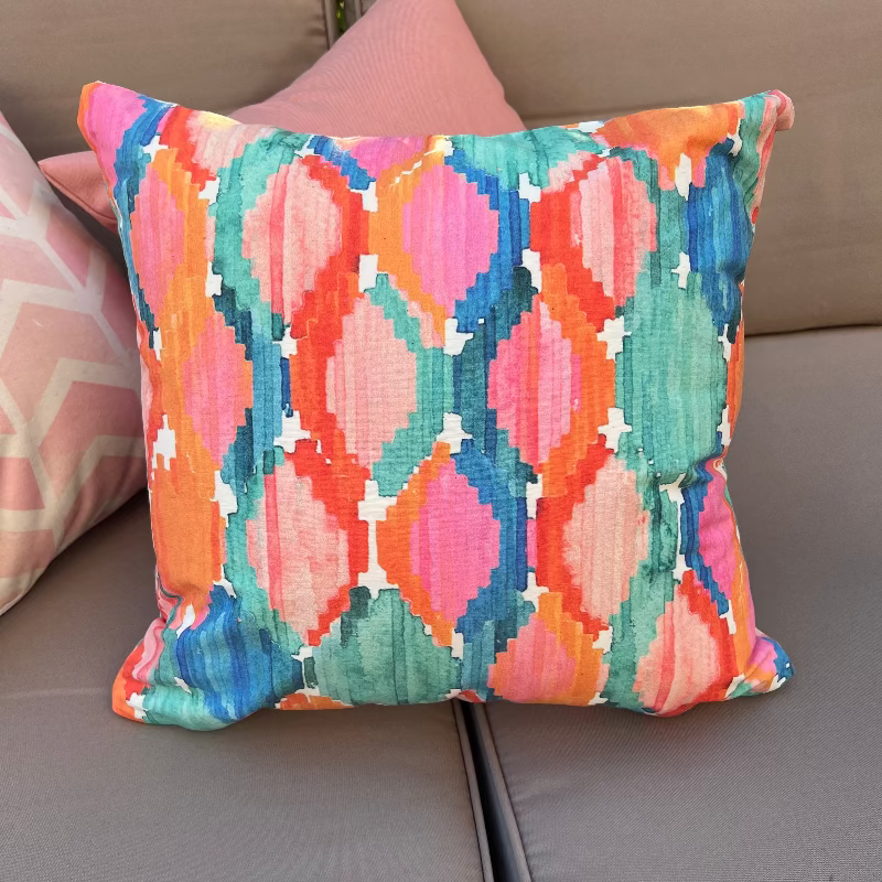 Colorful ikat pattern cushion cover with watercolor geometric design in teal, pink, and orange tones