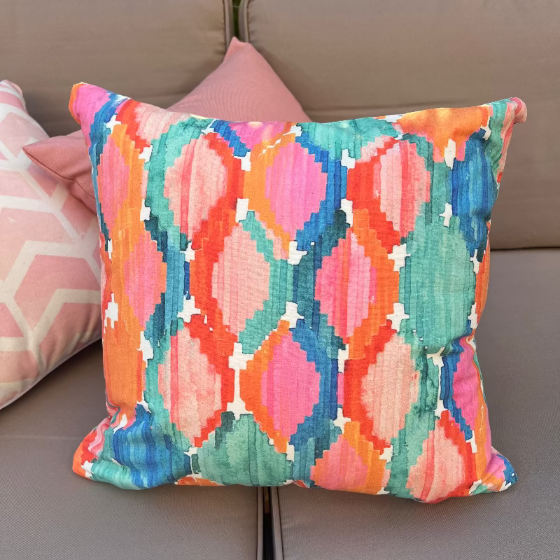 Colorful ikat pattern cushion cover with watercolor geometric design in teal, pink, and orange tones