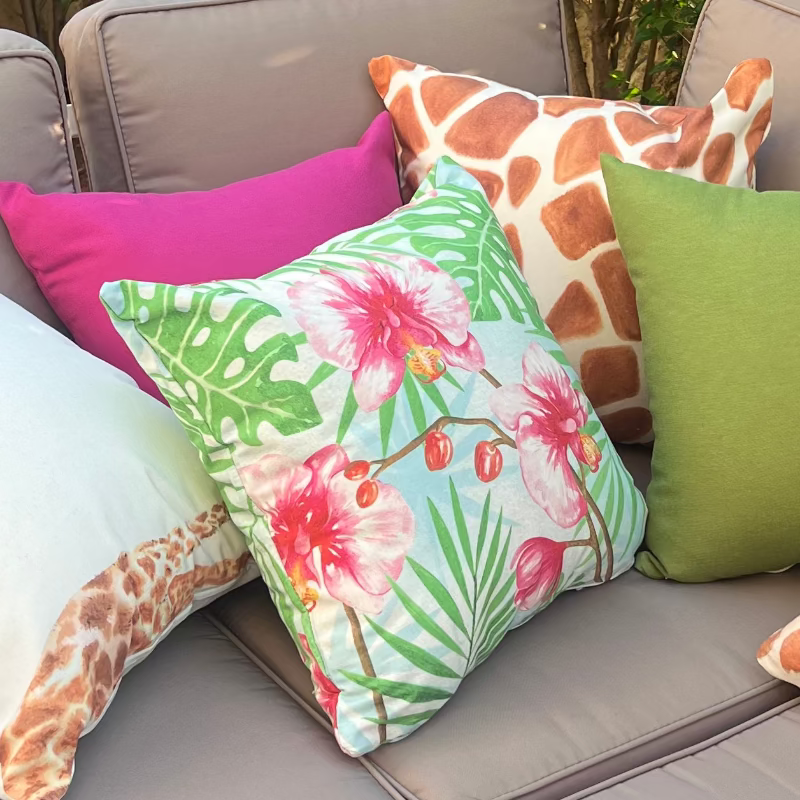 Tropical orchid cushion cover with pink flowers and green leaves on blue background decorative pillow