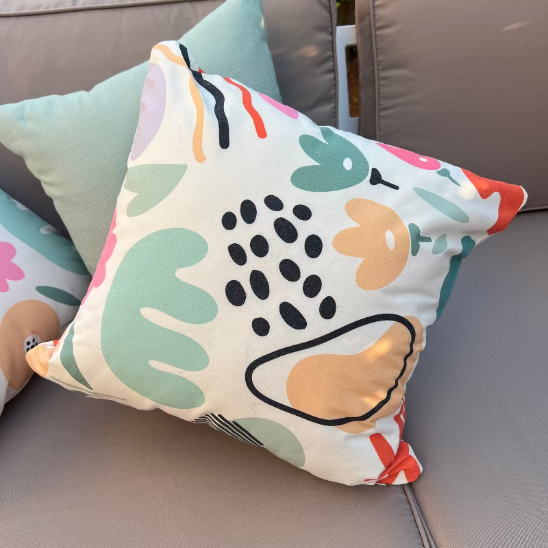 White cushion with pastel abstract shapes in a modern artistic pattern
