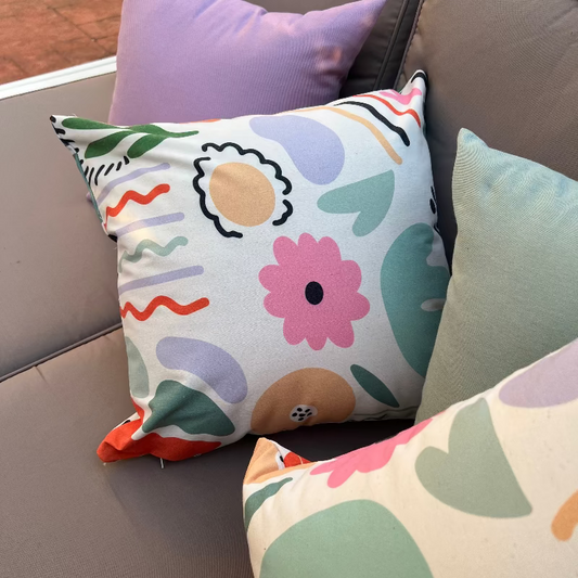 White cushion with colorful abstract shapes in a modern artistic pattern
