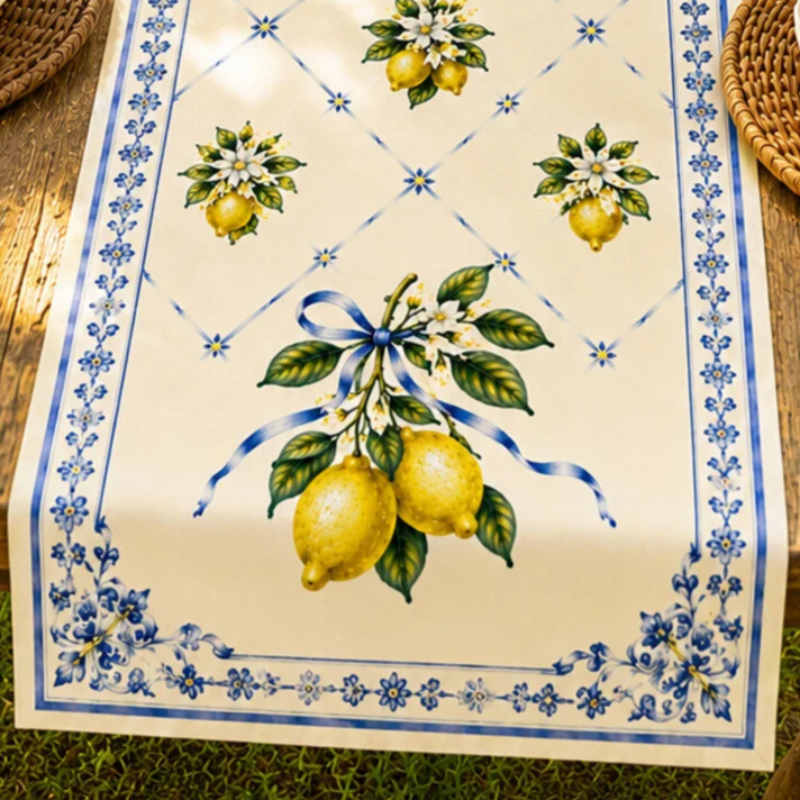 Set of four Mediterranean-inspired decorative cushion covers featuring lemons, citrus blossoms, blue ceramic vases, striped patterns, and traditional Italian tile motifs displayed on a neutral sofa.