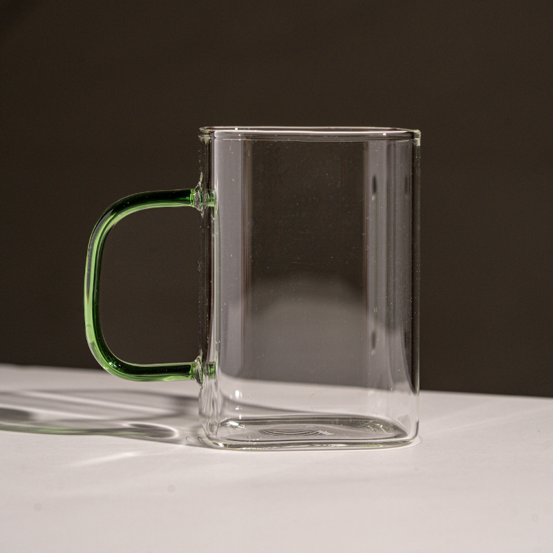 “Clear glass mug with collorful handle – modern minimalist design for coffee and tea