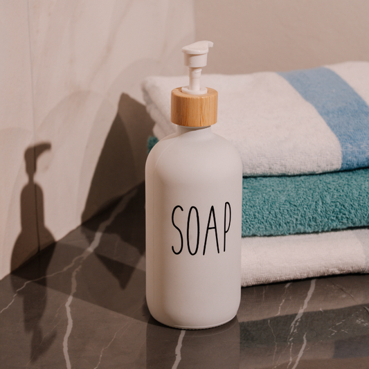 White soap dispenser with bamboo accent and minimalist text design