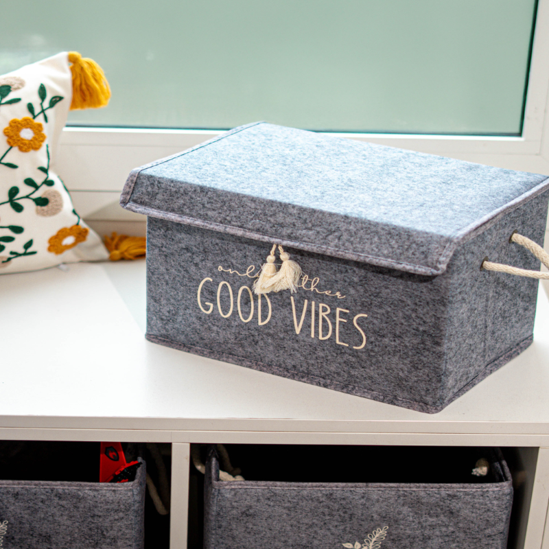 Felt storage box with lid and rope handles – Good Vibes print
Rectangular felt organizer box with tassel detail
Decorative storage box on white shelf for toys, clothes, or books