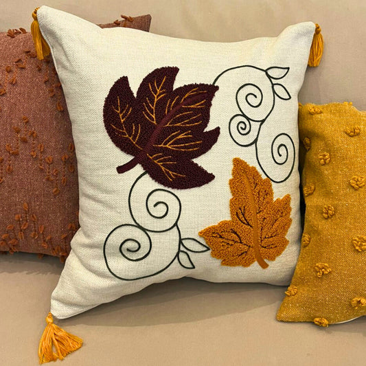 Square cushion cover with embroidered autumn leaves and tassels on beige sofa