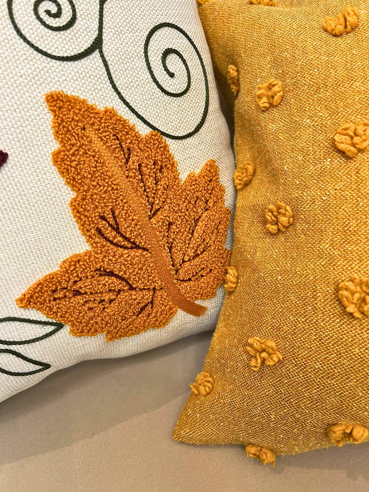 Square cushion cover with embroidered autumn leaves and tassels on beige sofa