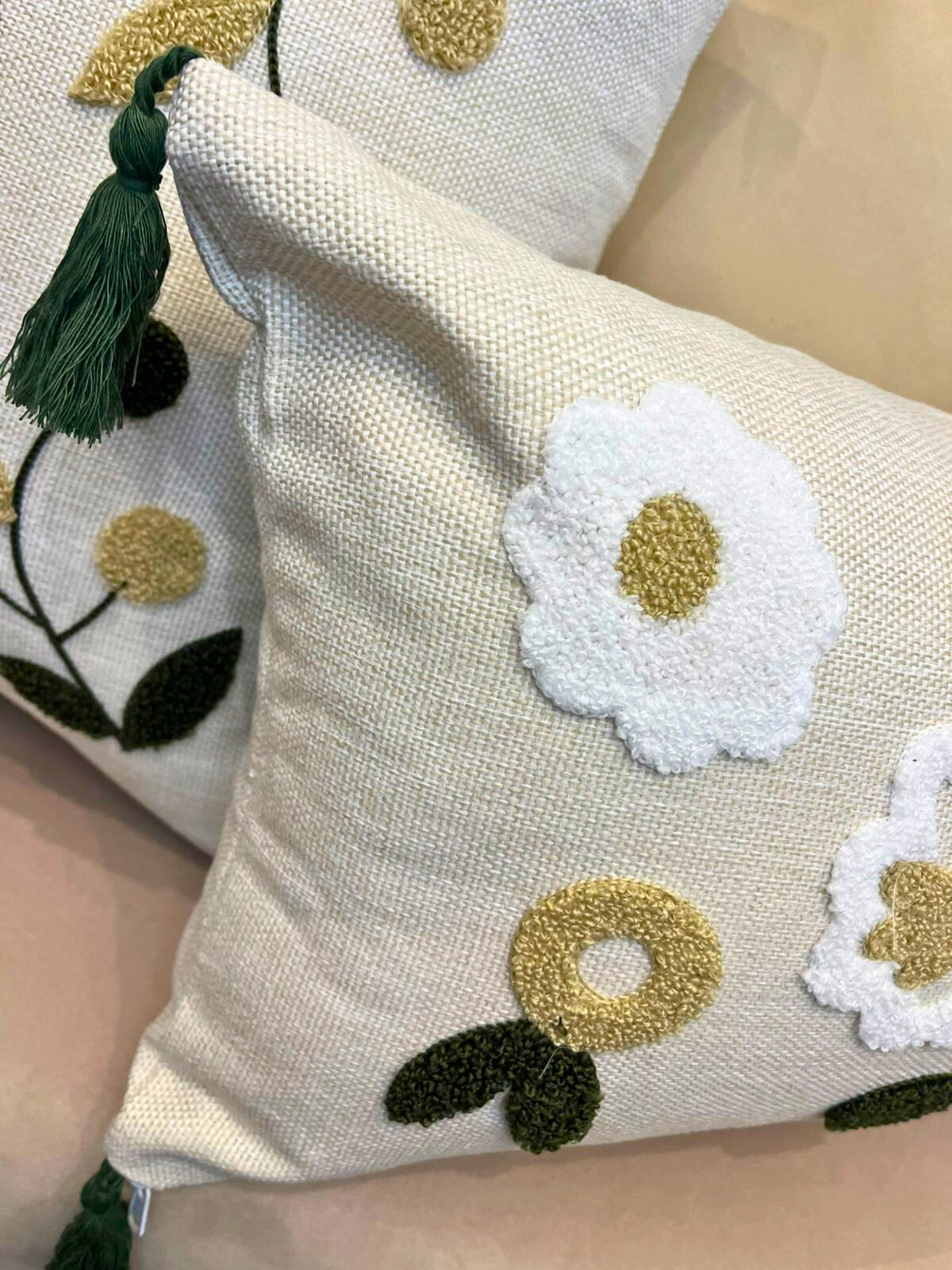 Rectangular embroidered floral cushion cover with tassels on beige sofa