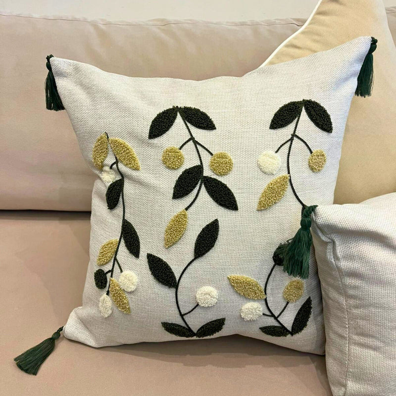 Square embroidered olive branch cushion cover with tassels on beige sofa