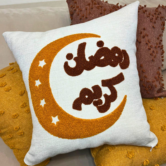 Square cushion cover with embroidered golden crescent moon and Arabic Ramadan Kareem text on sofa