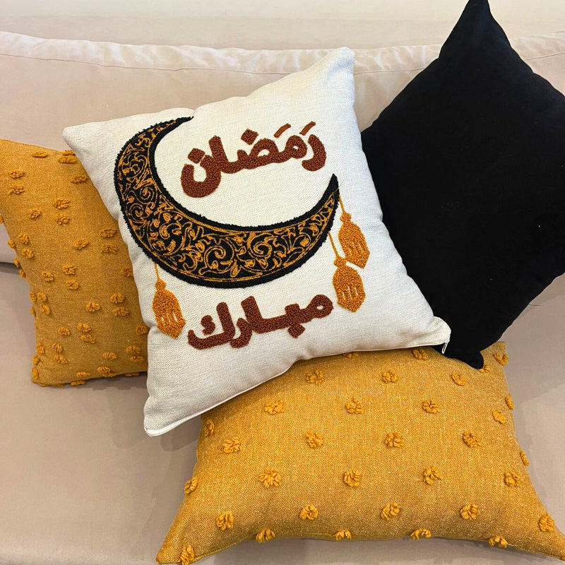 Square cushion cover with embroidered crescent moon and Arabic Ramadan Mubarak text on sofa